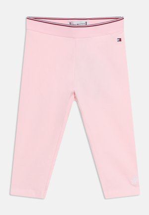 Jasnoróżowe legginsy dla małych dzieci z elastyczną talią, małym logo Tommy Hilfiger na biodrze oraz haftowanymi inicjałami na dolnej części nogawki.