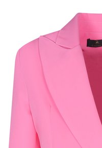 Blazer rosa con una texture liscia, caratterizzato da un ampio rever, una vestibilità sartoriale e hardware nascosto. Focalizzato su linee pulite e un colore vibrante.