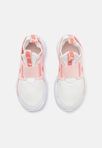Nike slip-on sneakers in pink and white, featuring a textured upper, elastic straps, and a cushioned white sole for comfort.