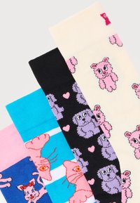 Τέσσερις πολύχρωμες κάλτσες με ζωικά μοτίβα: ροζ αρκούδες σε ανοιχτόχρωμο, μωβ σκυλιά με ροζ καρδιές σε μαύρο, ροζ γάτες σε μπλε και λευκές ρίγες, και ροζ γάτες σε ροζ φόντο.