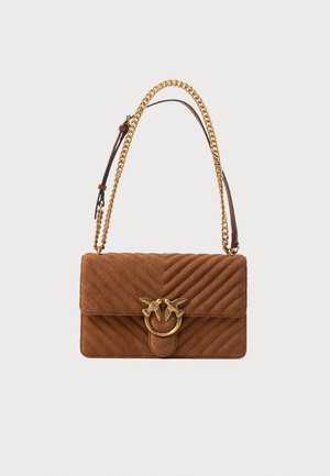 Sac à bandoulière matelassé marron avec une bandoulière chaîne dorée et un fermoir décoratif en forme d’oiseau doré sur le rabat avant.