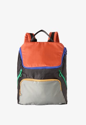 Sac à dos avec rabat supérieur orange, corps principal noir, poche avant grise et fermetures éclair bleues, vertes et jaunes présenté sur fond blanc.