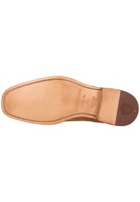Suela de zapato de cuero en un tono marrón claro con un acabado suave. Punta redondeada, costuras detalladas y un acento en el talón marrón. Presenta un logo en relieve.