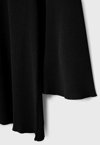 Tissu côtelé noir avec un design fluide. Présente une texture douce et un léger drapé. Les bords ont une finition lisse sans ornements.