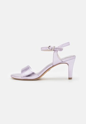 Lilac metallic open-toe sandal with ankle strap, silver buckle, and mid-height tapered heel on white background.