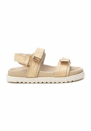 Sandalias beige de punta abierta con correas trenzadas y hebillas ajustables, que presentan una suela texturizada y una plantilla acolchada suave.