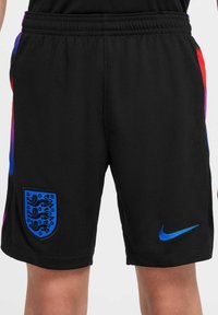Shorts de sport noirs avec un logo Nike bleu, un blason de l'Angleterre en bleu, et des accents en dégradé rouge et bleu sur les côtés. Tissu léger.