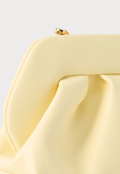 Pochette en cuir jaune doux avec un design plissé et une fermeture à rabat en métal doré en haut, sur un fond uni.