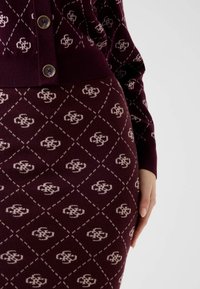 Pletené šaty v bordó barvě s diamantovým vzorem a kontrastními světlými akcenty. Mají přiléhavý střih a zapínání na knoflíky.