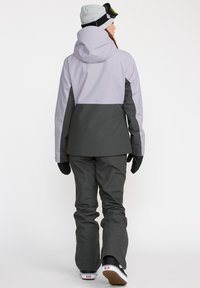 Skijack en -broeken in grijs en lichtlavendel, met een capuchon, lange mouwen en handschoenen. Gladde, waterdichte stof met een ontspannen pasvorm.