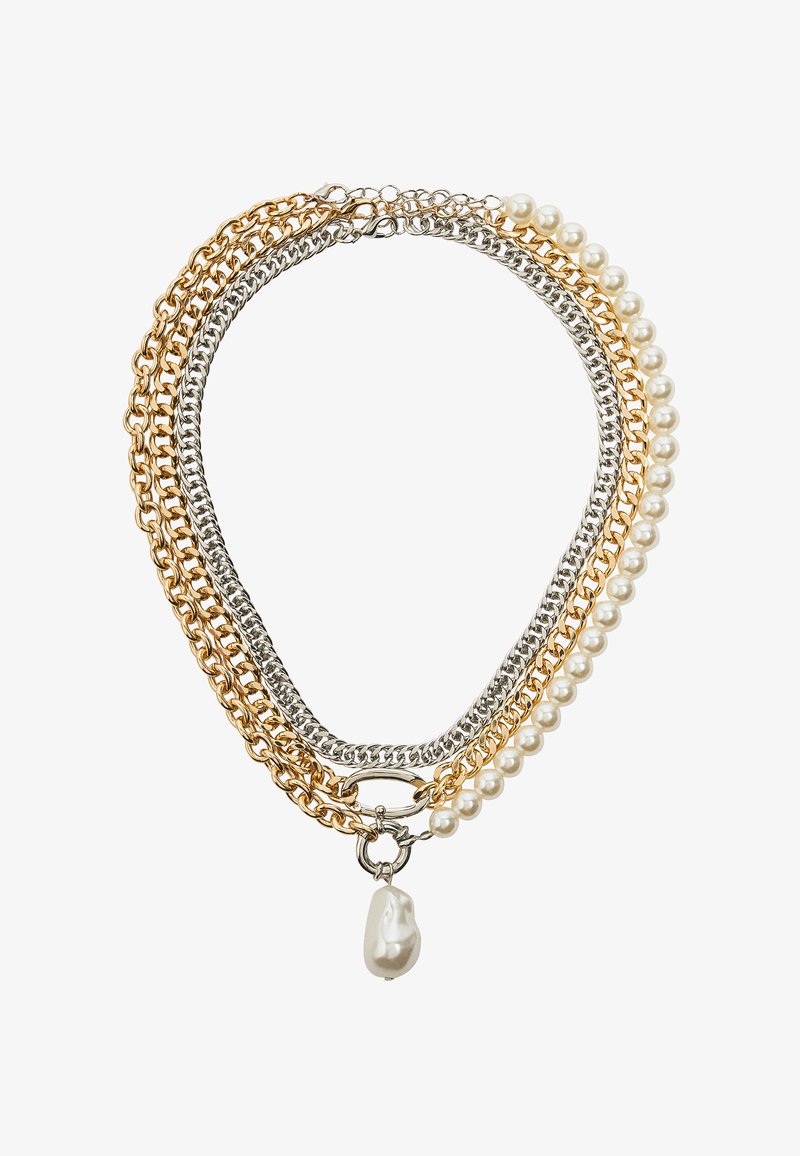 Naszyjnik warstwowy z łańcuchami w kolorze złota i srebra oraz białymi perłami. Zawiera wyraźny akcent w postaci nieregularnie uformowanej kropli perły.
