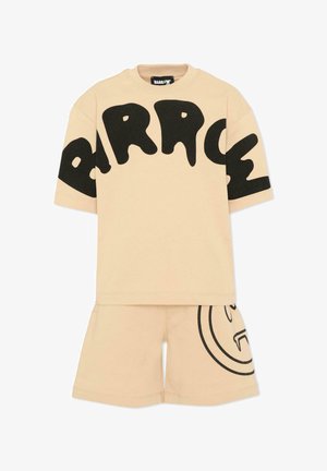 Chemise beige à manches courtes avec un grand texte noir "BARROW" sur la poitrine et un short beige assorti avec un design partiel de visage souriant noir.