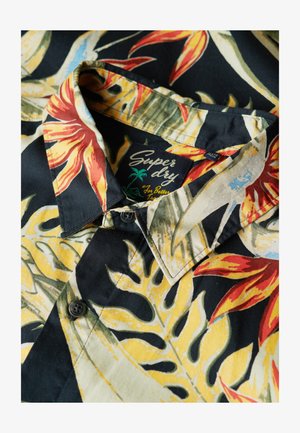 Chemise à manches courtes avec un fond noir ornée de motifs floraux rouges et jaunes. Tissu doux, fermeture à boutons et col pointu.