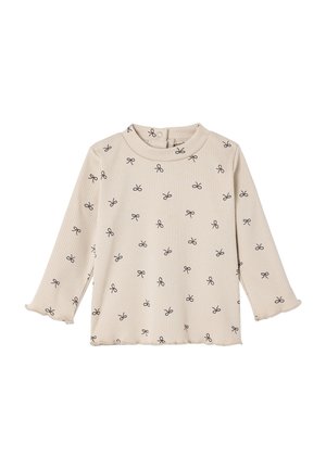 Beige ribbed long-sleeve top featuring a rounded neckline and black bow pattern. Ruffled cuffs accentuate the sleeves.