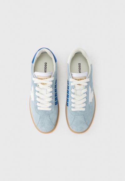 Ανοιχτό μπλε σουέντ αθλητικά παπούτσια με λευκές λεπτομέρειες και μπλε ρίγες. Διαθέτουν λευκά κορδόνια, σόλα από καουτσούκ και μικρό λογότυπο στη γλώσσα.