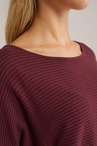 Burgundi spalvos nusitampantis mezginys su plačiu iškirpimu ir minkšta tekstūra, papuoštas vertikaliomis linijomis, kurios sukuria subtilų raštą.