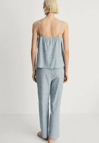 Lichtblauwe, gestreepte pyjama-set met een losse camisole met verstelbare bandjes en bijpassende, wijdvallende broek. Zachte, gestructureerde stof.