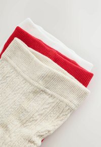 Sæt af tre par sokker: én rød, én hvid og én beige. De har ribbede manchetter og et struktureret strikkemønster for ekstra detaljer.
