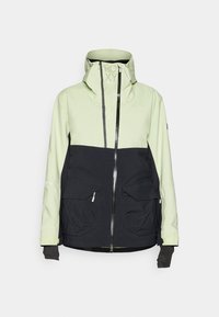 Giacca impermeabile con parte superiore verde chiaro e sezione inferiore nera, due tasche frontali, chiusura con zip e cappuccio regolabile.