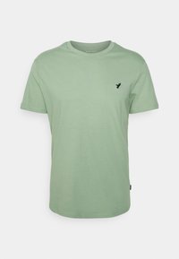 T-shirt mint verde a maniche corte realizzato in morbido cotone, con un logo nero sottile sul petto e un classico collo a giro.