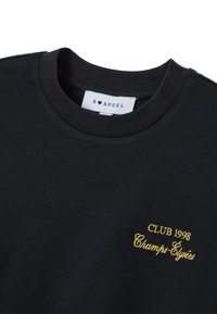 Sudadera de algodón negra con cuello redondo, con texto amarillo bordado "CLUB 1998 Champs-Élysées" en el frente.