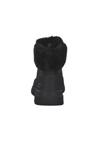 Botas negras hasta el tobillo con un suave cuello forrado de piel. El exterior presenta un acabado de cuero suave y una suela acolchada para mayor comodidad.