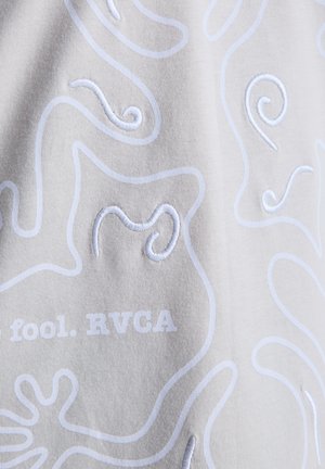 Tessuto grigio chiaro con motivi a spirale ricamati in bianco e testo "fool. RVCA" in basso, che mette in risalto la trama e i dettagli intricati del design.