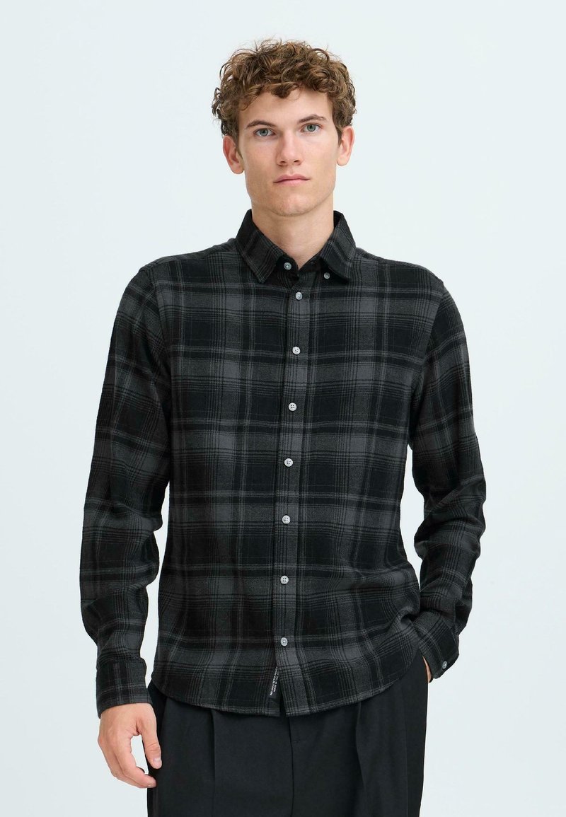 Black and gray plaid shirt with a button-down collar, long sleeves, and front buttons. Soft, textured fabric with a relaxed fit.