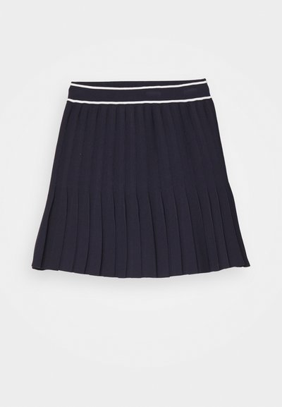 Jupe plissée marine avec une finition texturée, dotée d'une taille plate accentuée par deux rayures blanches en haut.