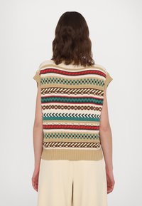 Top sin mangas de punto con rayas horizontales en verde, rojo, marrón y crema. Dobladillo acanalado con varios patrones y detalles texturizados.