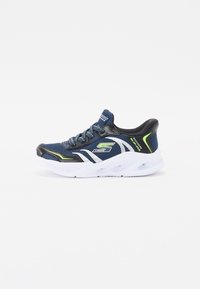 Baskets de sport bleues avec tige en maille, accents noirs, détails réfléchissants argentés et éclats verts vifs. Présente une semelle en caoutchouc blanche.