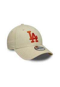 Gorra de béisbol beige con visera curva, que presenta un logo bordado de "LA" en naranja en la parte frontal y una correa ajustable en la parte posterior.