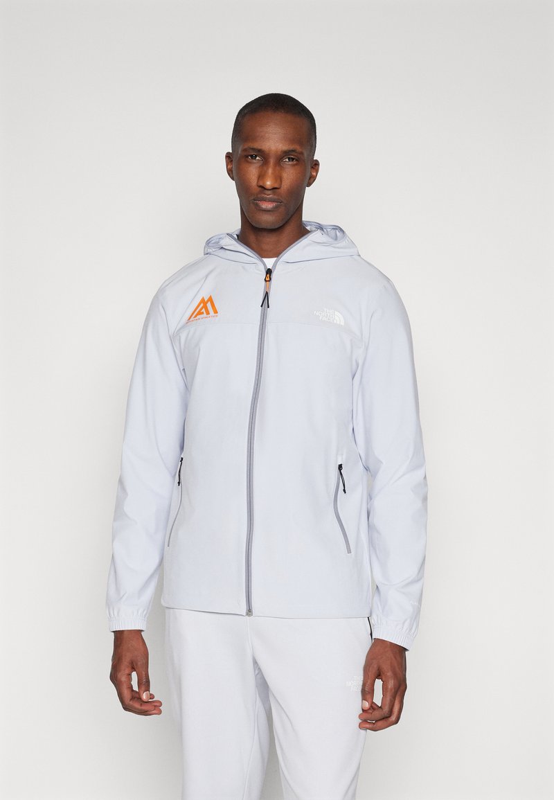 Šviesiai pilkas zip-up džemperis su kapišonu. Turi oranžinius logotipo akcentus ir elastingas rankoves, pagamintas iš švelnios, lengvos medžiagos.