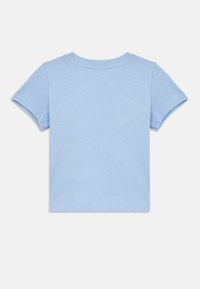 Ανοιχτό μπλε κοντομάνικο μπλουζάκι από μαλακό βαμβάκι. Λεπτομέρειες με επίπεδες ραφές στα μανίκια και το λαιμό, με απλή, χωρίς διακοσμήσεις πλάτη.