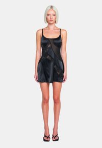 Robe en satin noir avec des panneaux transparents, des bretelles spaghetti et un motif en vagues. L'ourlet est au-dessus du genou, créant une silhouette ajustée.