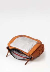 Braune Ledertasche mit strukturiertem Oberteil. Das Innere hat ein Gittermuster-Futter und eine rote Reißverschlusstasche. Reißverschlussverschluss mit verstellbaren Riemen.