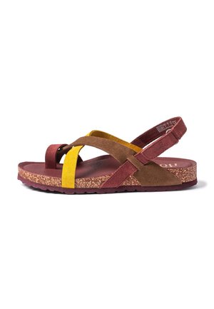 Flat sandal with cork sole, featuring overlapping yellow, brown, and burgundy suede straps, and an adjustable heel strap.