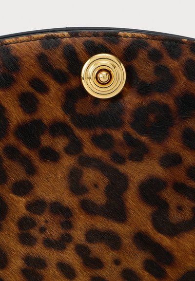 Leopárdmintás szövet barna és fekete foltokkal. Arany kör alakú fém részlet a tetején. Puha textúra, enyhe fénylő hatással.