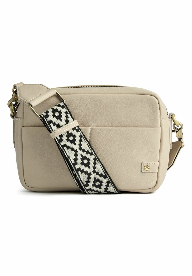 Borsa a tracolla in pelle beige con tracolla a pattern bianco e nero, parte superiore con zip, tasca frontale e dettagli in metallo dorato.