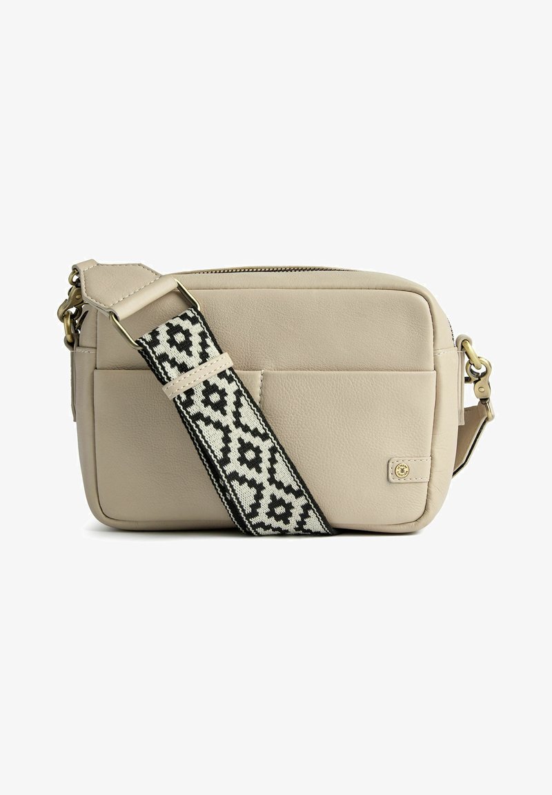 Beige läder crossbody-väska med svart och vit mönstrad axelrem, dragkedjestängning, framficka och detaljer i guldton.