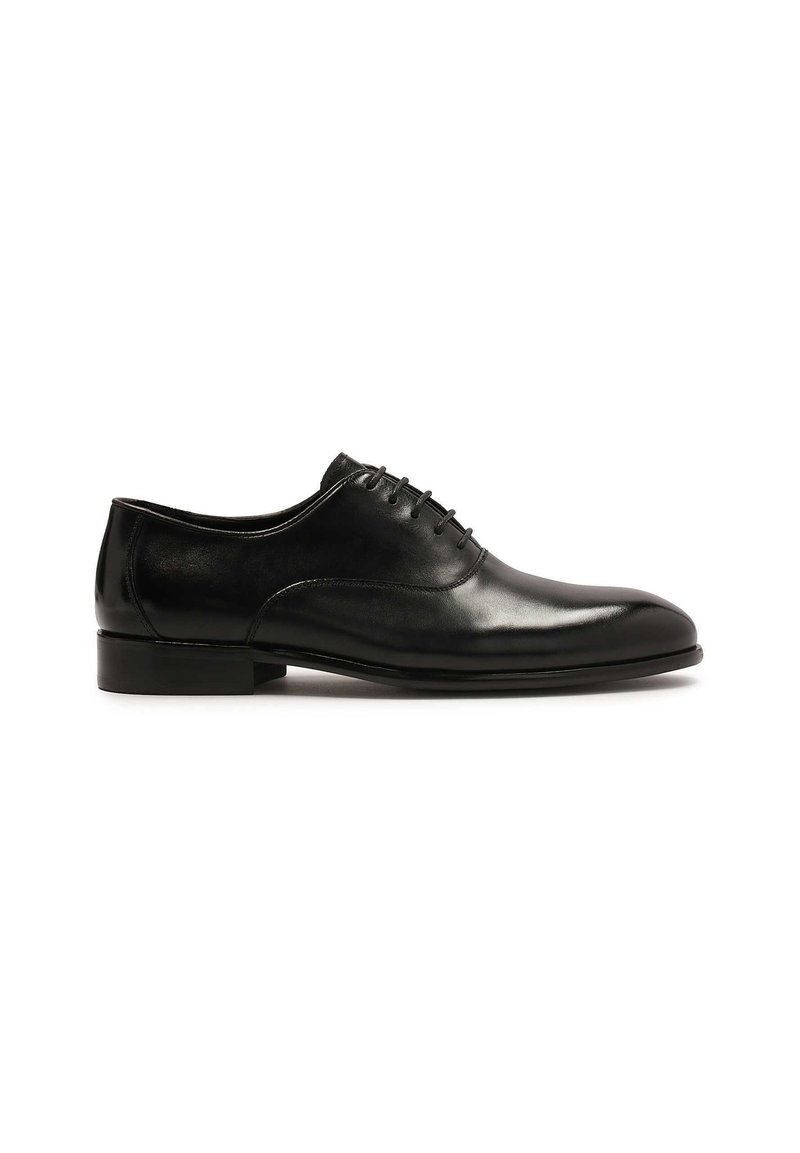 Scarpa da uomo in pelle nera, con finitura liscia, punta tonda e sei fori per i lacci. Presenta un tacco basso a blocco e un design minimalista.