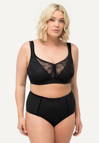 Zwarte kant bralette met bredere schouderbanden, een doorzichtig voorpaneel en bijpassende high-waisted slips met een zachte stof en naadloos ontwerp.