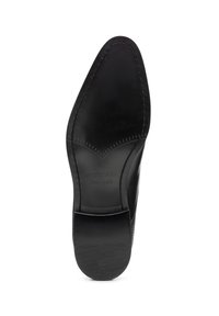 Schwarze Ledersohle eines Schuhs mit spitzer Zehenpartie, strukturiertem Design und dem eingeprägten Markennamen „WITTCHEN handmade“ nahe der Ferse.