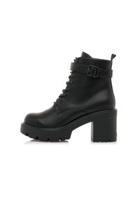 Botte chelsea en cuir noir avec un talon épais, un avant à lacets et une sangle décorative à boucle. Caractéristiques : semelle robuste et bout arrondi.