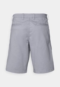 Harmaat puuvillahousut suoran istuvuuden omaavina, joissa on kaksi takataskua ja vyötärönauha vyölenkeillä. Sileä pinta, ilman näkyviä kuvioita tai yksityiskohtia.