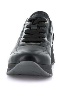 Scarpa da ginnastica nera in pelle con punta arrotondata, design con lacci, colletto imbottito e suola in gomma resistente. Texture liscia con accenti minimi.