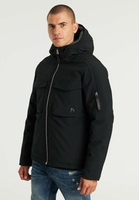 Chaqueta negra con capucha, dos bolsillos en el pecho, cierre de cremallera y detalle de logo en la manga; presenta un tejido liso y estructurado.