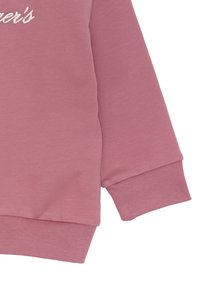 Felpa in cotone rosa con collo a giro e polsini a costine. Decorata con testo ricamato bianco sul davanti. Texture morbida.