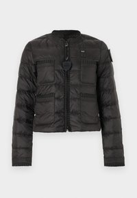 Μαύρο καπιτονέ μπουφάν με τέσσερις τσέπες μπροστά, λεπτομέρειες ριμπ και φερμουάρ μπροστά με στρογγυλό τμηματικό τράβηγμα.