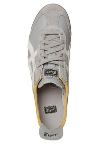 Šedá sneaker vyrobená z kůže a semiše, s texturovaným svrškem, plochými šňůrkami a žlutým interiérem. Logo na stélce a patě.